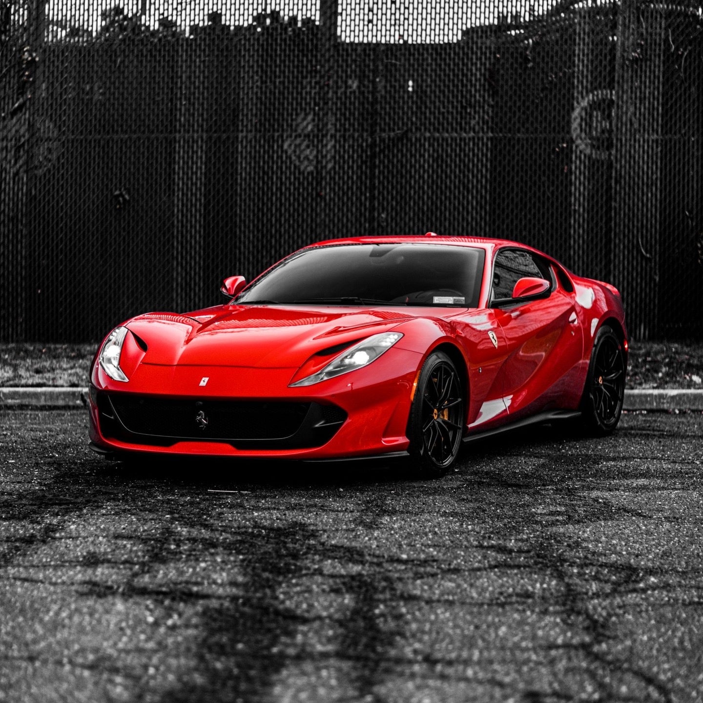 Red luxury sports car with sleek aerodynamic design, black alloy wheels, and tinted windows parked on asphalt, perfect for high-performance driving enthusiasts.