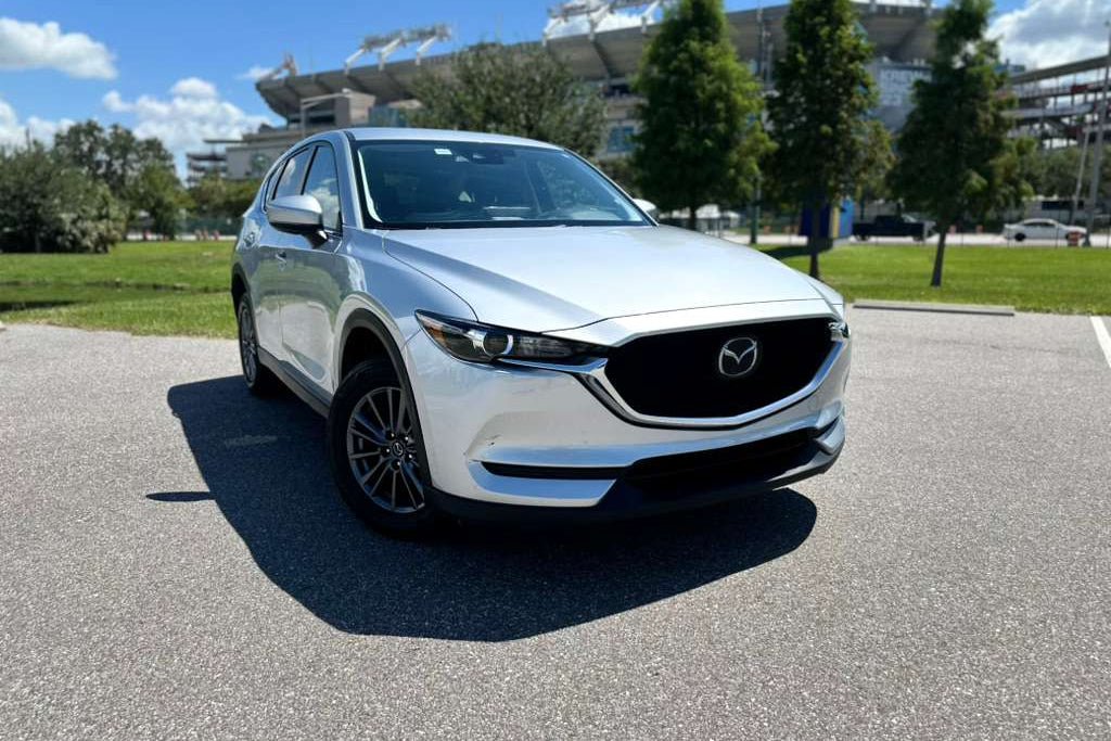 Silver Mazda CX-5 compact SUV parked outdoors on a sunny day, featuring sleek design and alloy wheels.