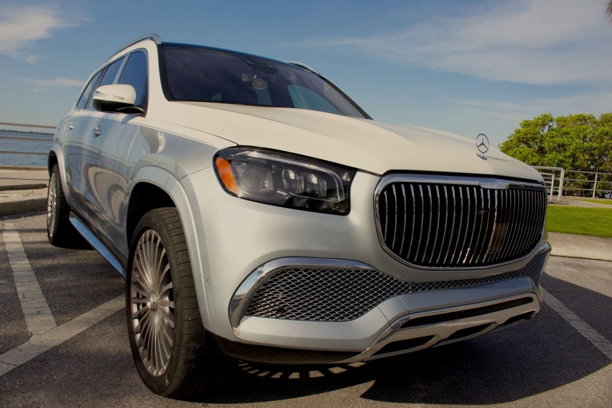 White luxury Mercedes-Maybach SUV parked outdoors, premium modern design with chrome grille and alloy wheels, high-end German luxury car for sale.